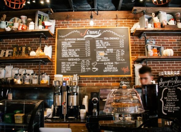 Interior of a cozy urban café with a chalkboard menu and espresso machines, resembling the setting in the Learn-Hive blog story.