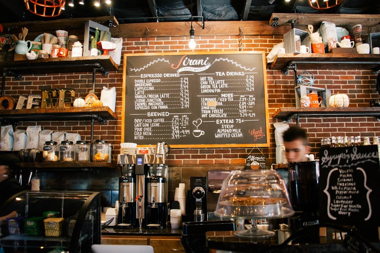 Interior of a cozy urban café with a chalkboard menu and espresso machines, resembling the setting in the Learn-Hive blog story.