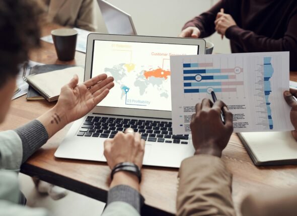 Professionals discussing data during a business meeting with charts and global strategy on screen