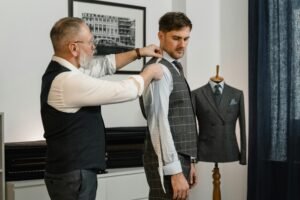 A tailor adjusting a bespoke suit in a refined atelier, symbolizing customized English lessons.